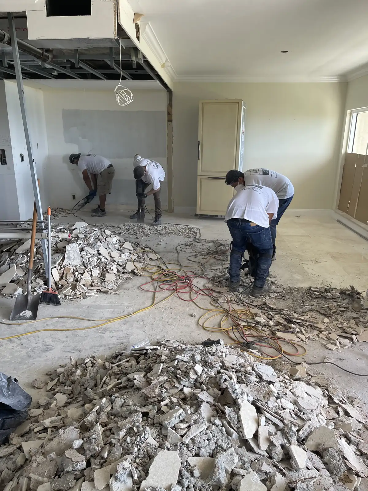 Apadana Group Inc. crew removing old flooring and debris during an interior remodel