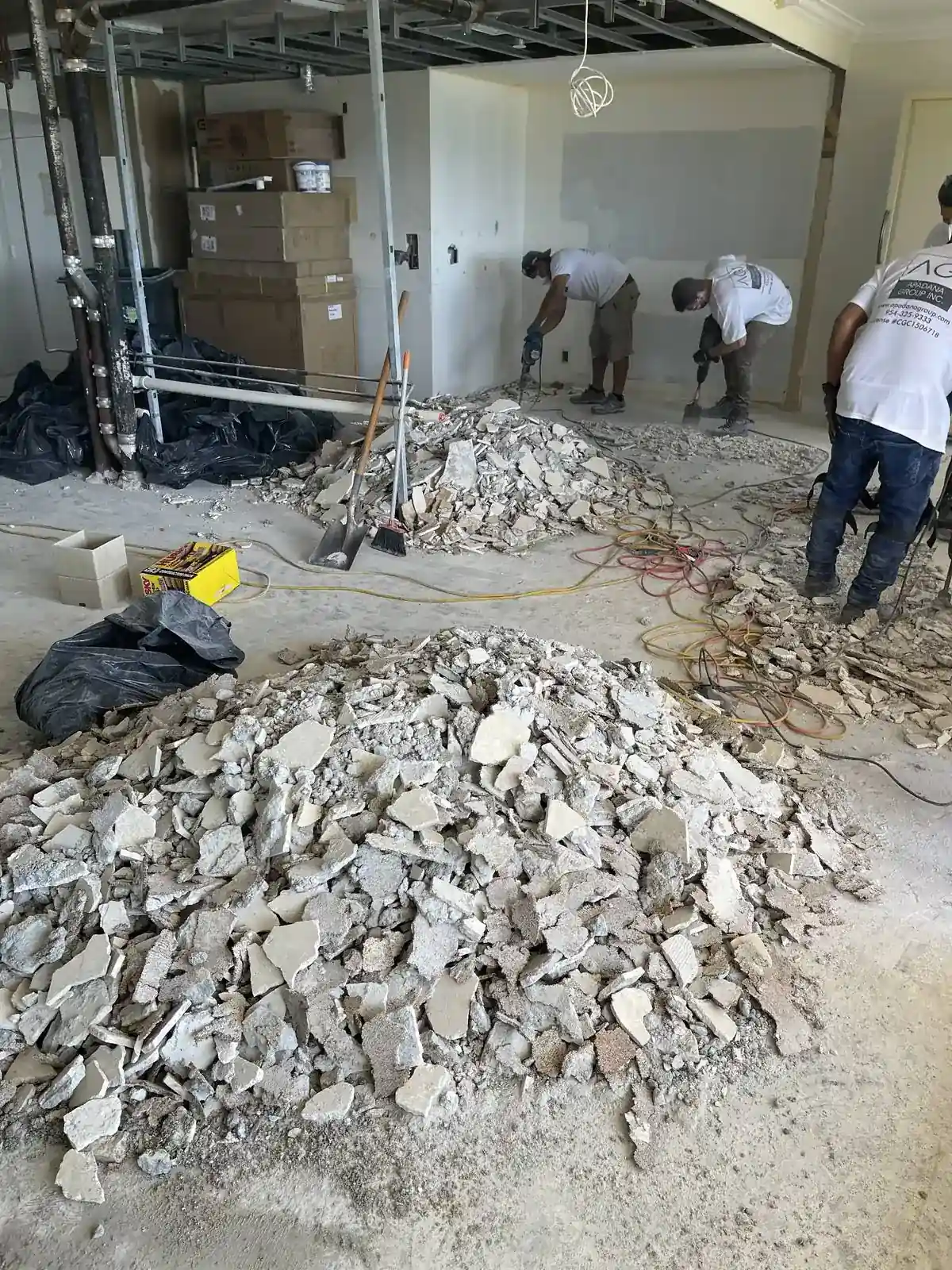 Apadana Group Inc. crew removing old floor tile and debris before interior repairs