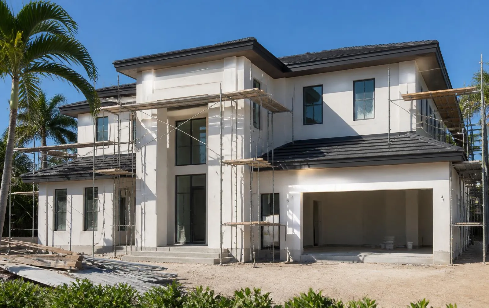 Modern South Florida home under construction with stucco walls and scaffolding