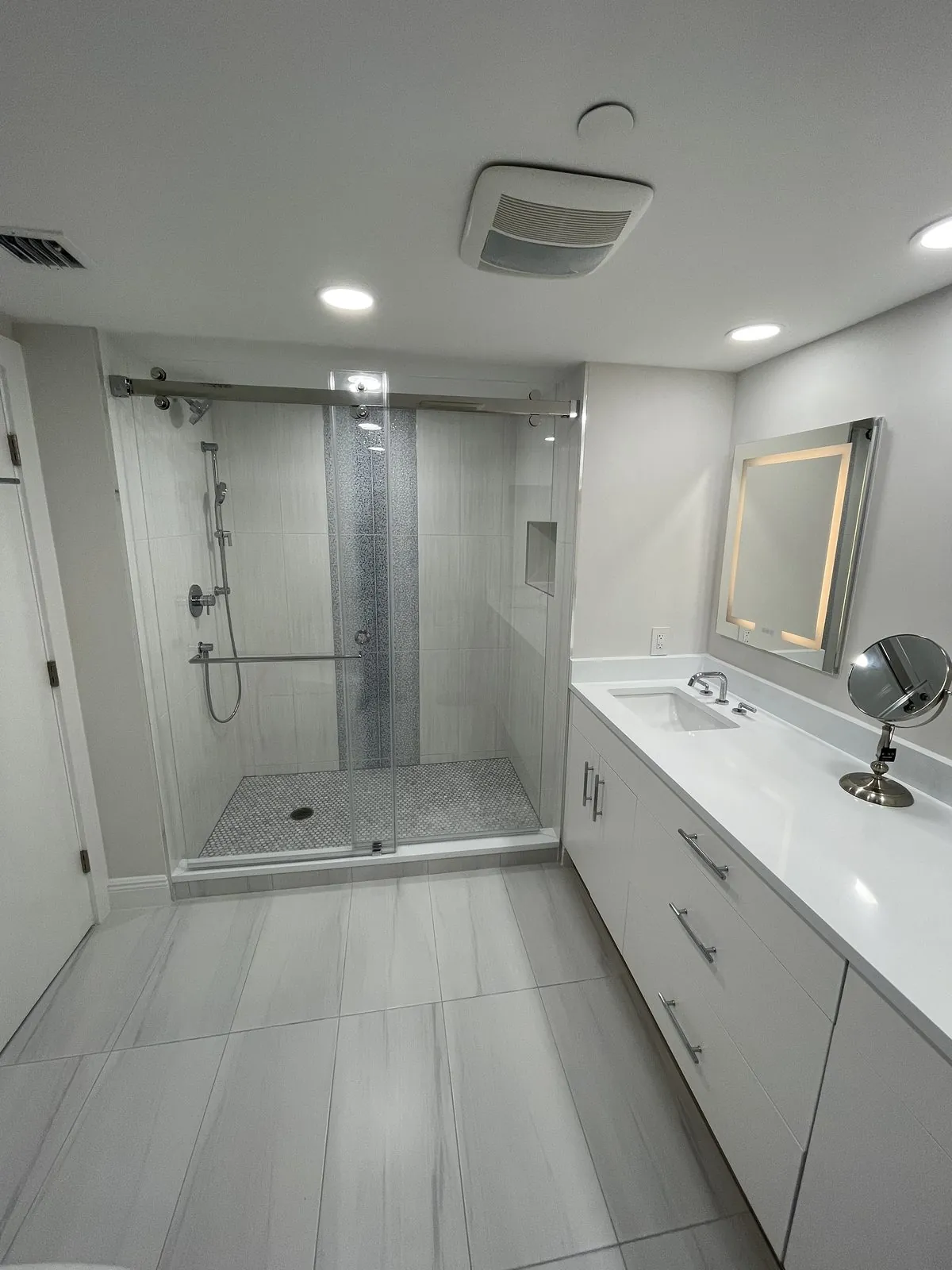 Bathroom with frameless glass walk-in shower and white vanity