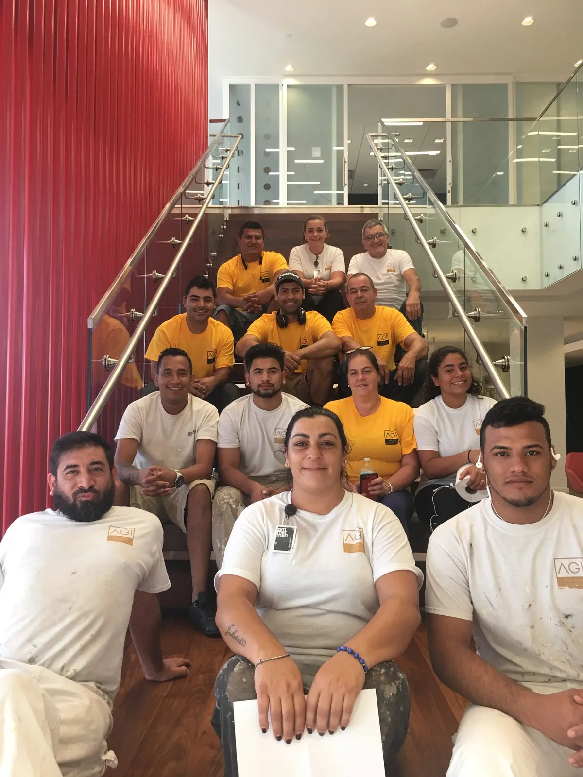 Apadana Group Inc. crew in company shirts seated on a staircase