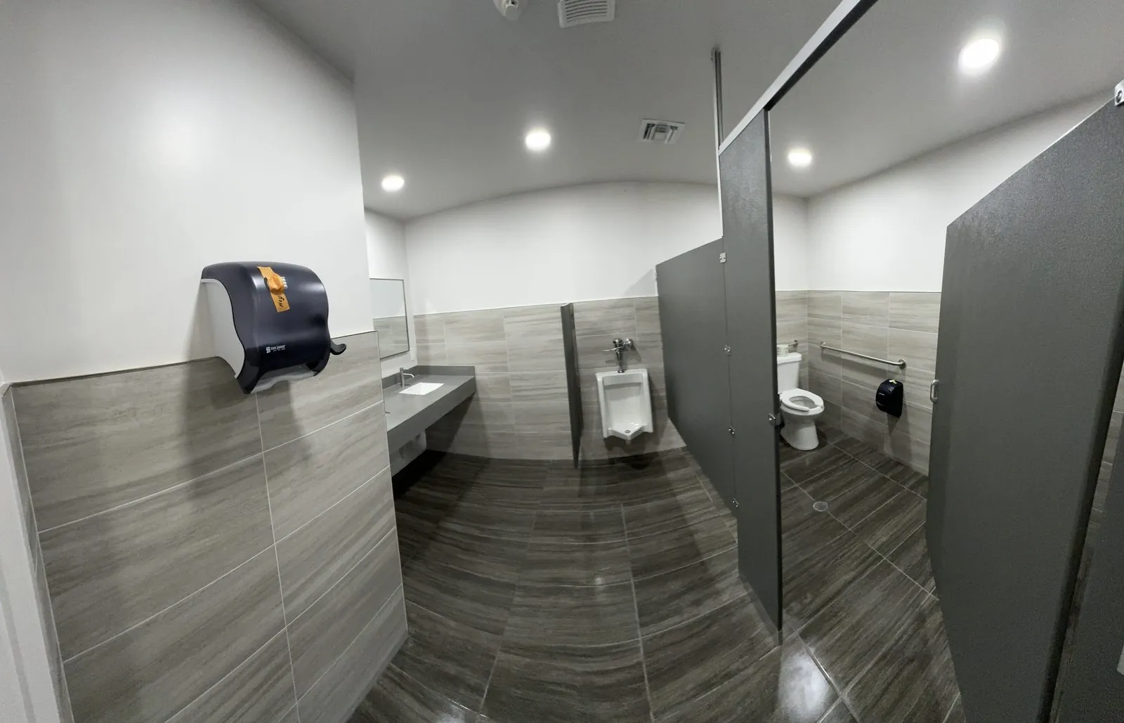 Commercial restroom with porcelain wall tile and gray partitions