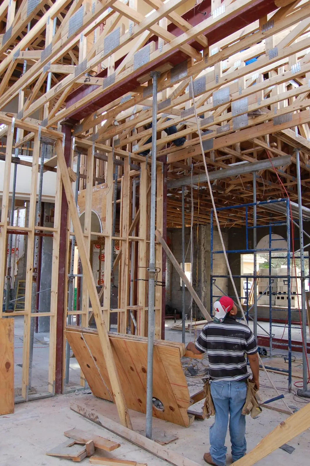 Wood wall framing and roof trusses during custom home construction by Apadana Group Inc.