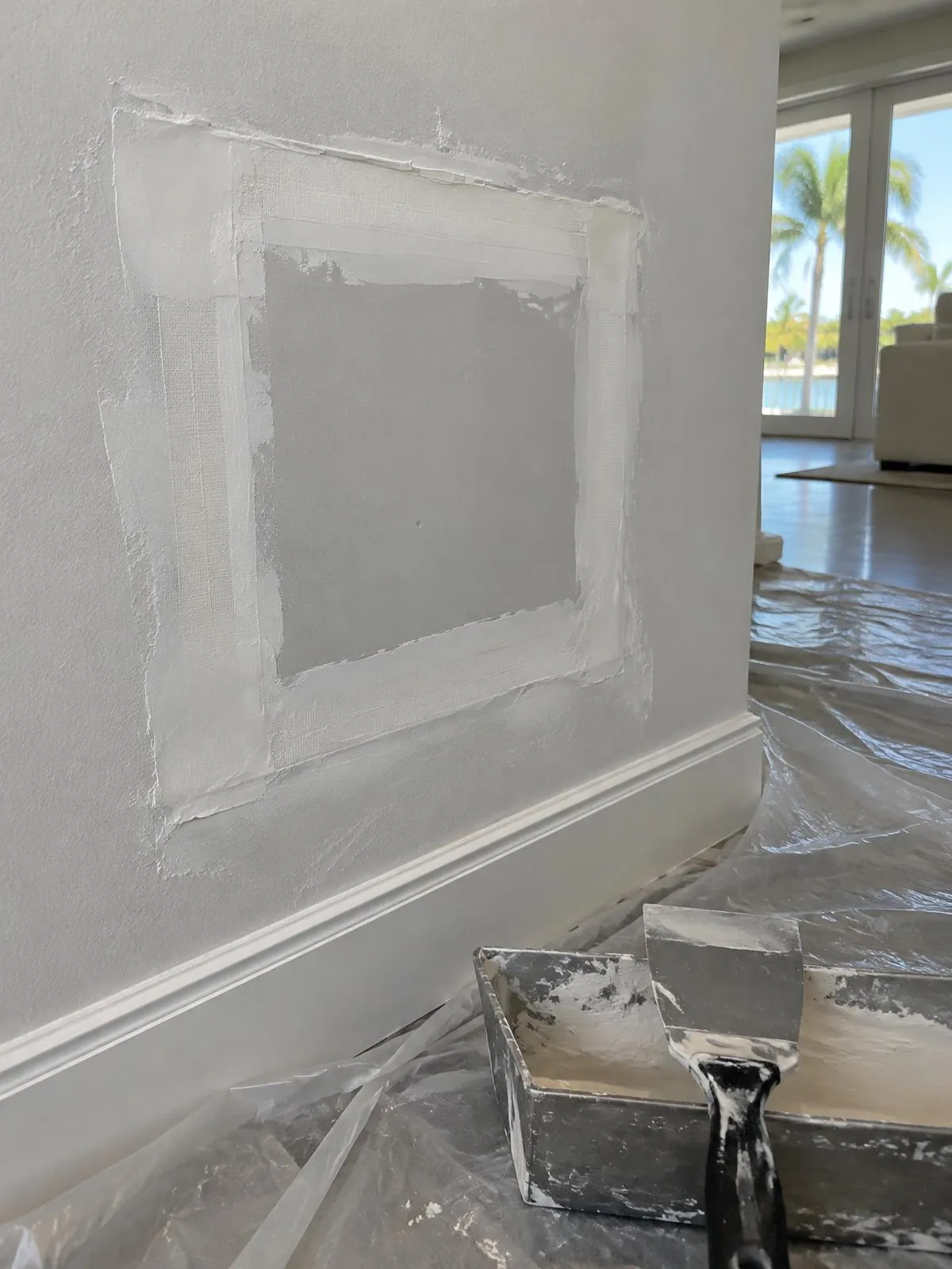 Interior drywall patch with taped seams and joint compound before sanding and paint